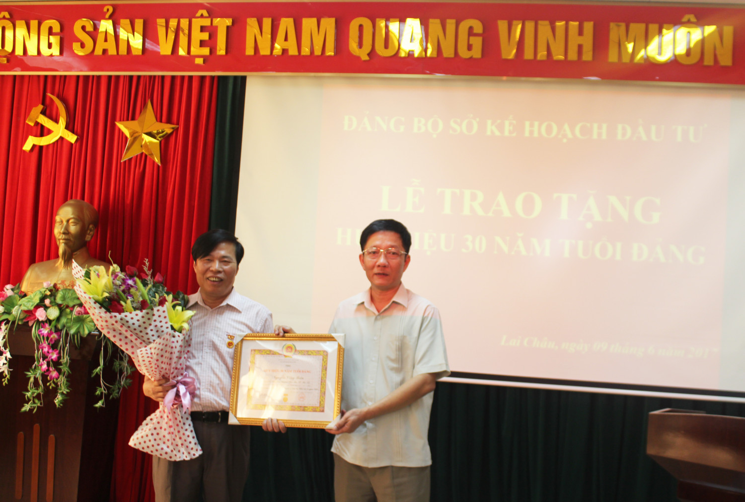 Đồng chí Nguyễn Quang Huy - Bí thư Đảng bộ trao quyết định và huy hiệu 30 năm tuổi Đảng cho đồng chí Nguyễn Công Biên.